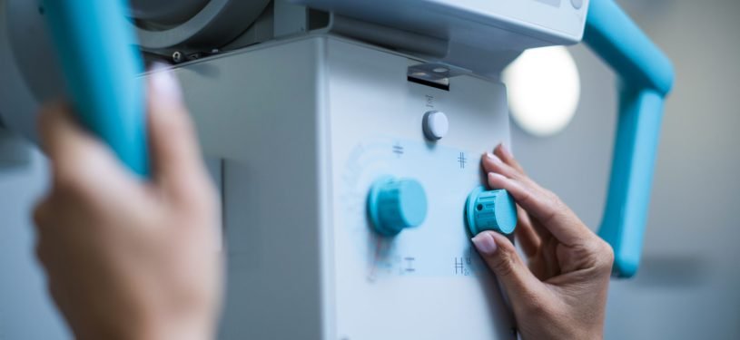 Doctor sets up the machine to x-ray over patient in hospital